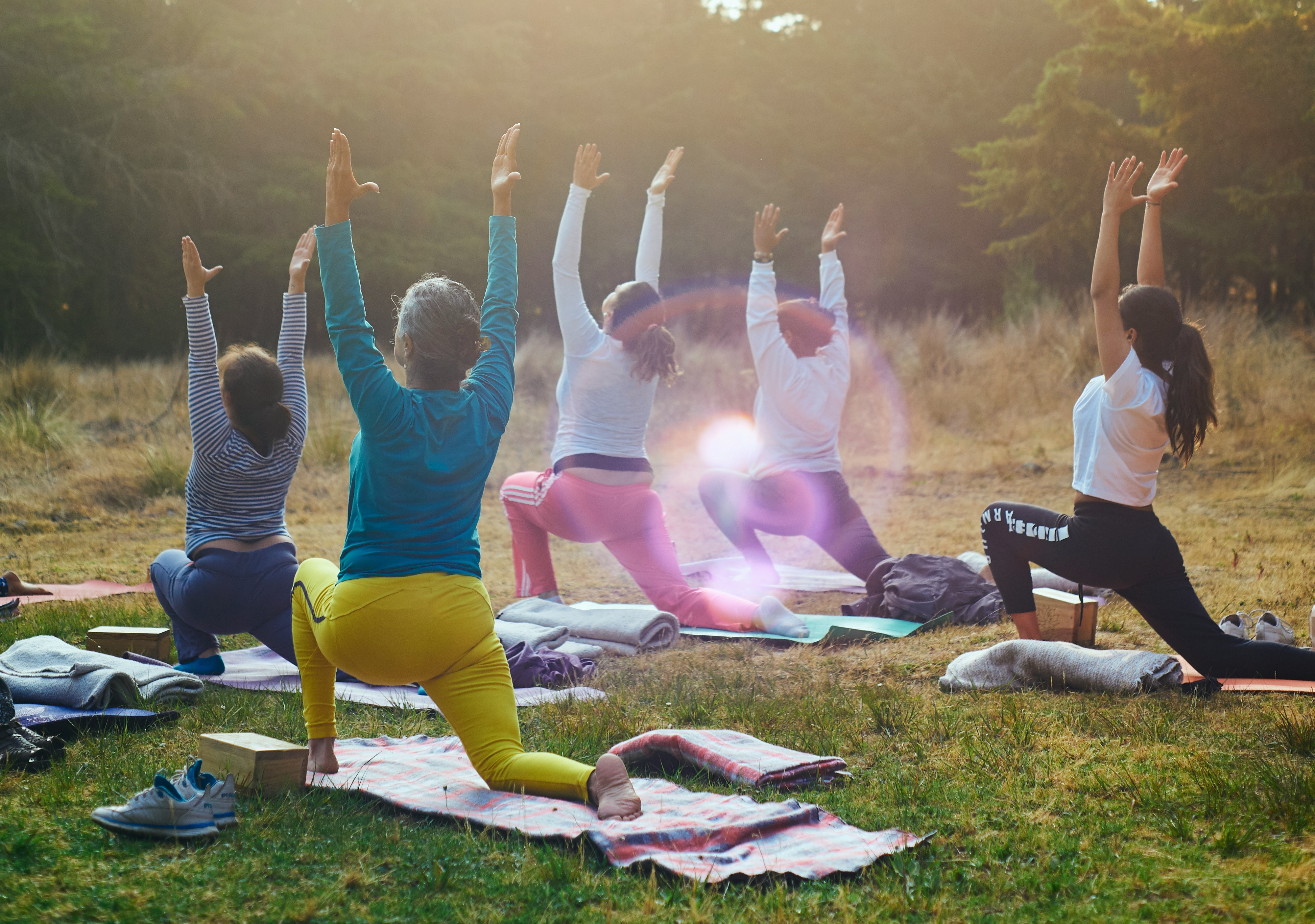 A small group of people practicing yoga on a sunny day